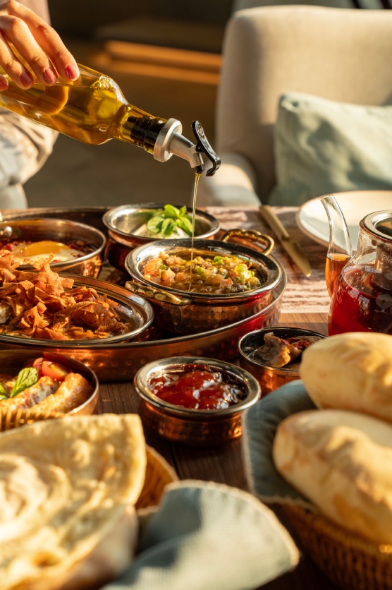 olive oil being poured over fresh hummus at ghusoun lebanese restaurant